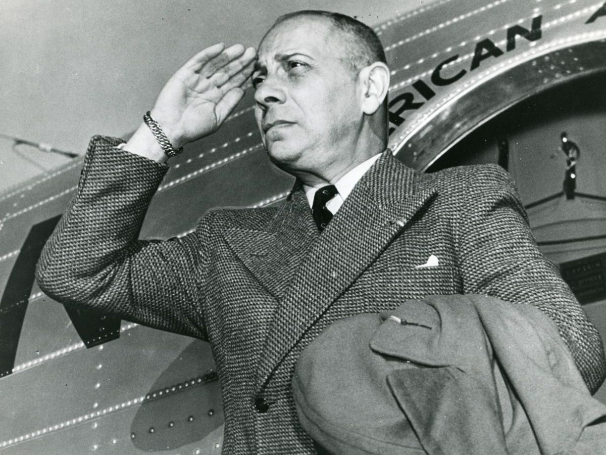 A salute as he exits an American Airlines plane, 1950s